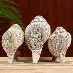 Engraved Shankha Wealth Conch – close-up of Buddha hand gesture holding jewel, mudra detail carving