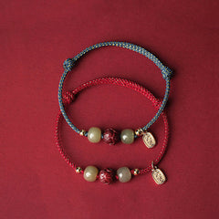 Hetian Jade Cinnabar Lotus Bracelet – Blue and red cord color options shown together on dark red, two tone bracelet