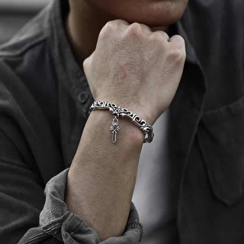 Viking twisted braided copper balance bracelet with oxidized silver finish intricate Celtic scrollwork and cross pendant worn on wrist with charcoal shirt