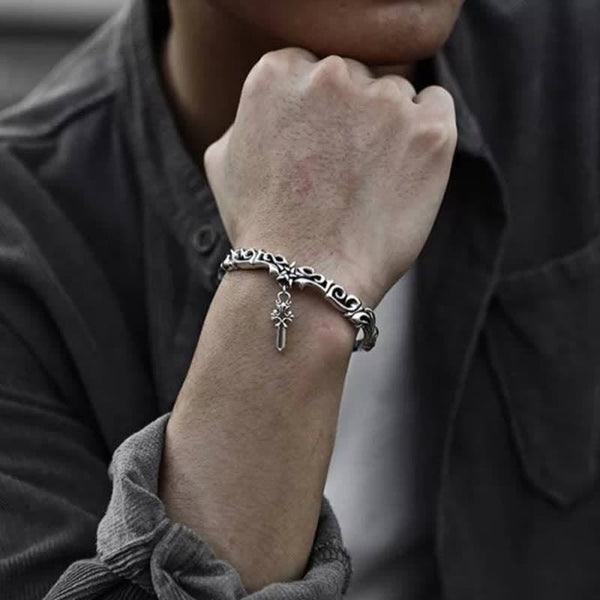 Viking twisted braided copper balance bracelet with oxidized silver finish intricate Celtic scrollwork and cross pendant worn on wrist with charcoal shirt