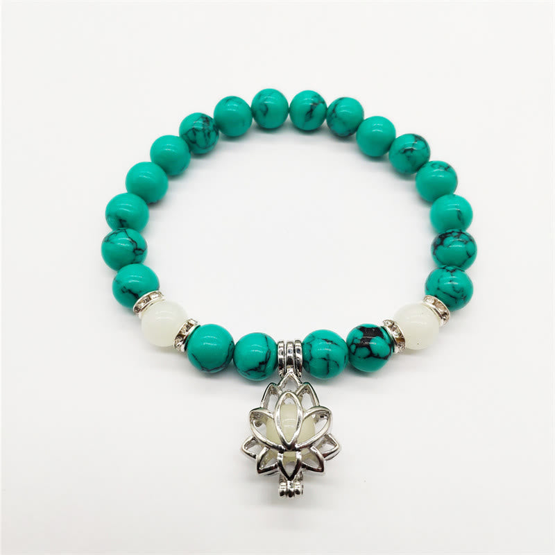 Tibetan Turquoise Glowstone Lotus Bracelet – turquoise beads with white accent beads and silver lotus charm, white background, turquoise bracelet
