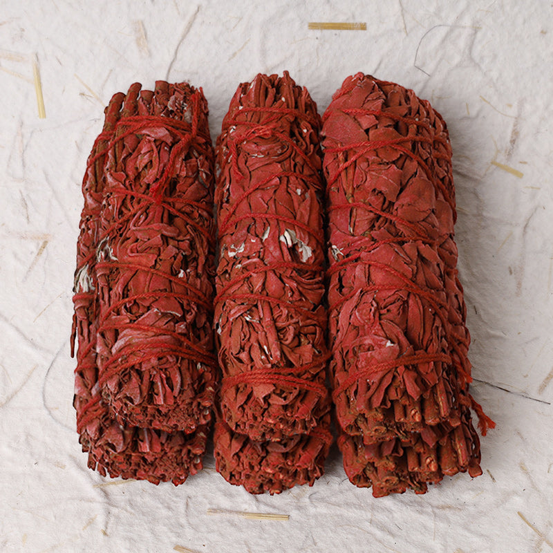 Dragon's Blood sage smudge – three upright red bundles on textured paper, protective
