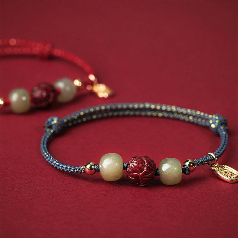 Hetian Jade Cinnabar Lotus Bracelet – Blue cord foreground with blurred red variant behind, depth of field shot
