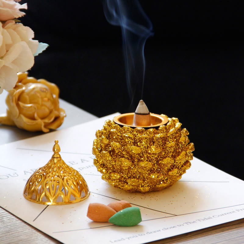 Gold Pine Cone Mini Incense Burner - Open base with smoke, cream roses, dark backdrop, luxury home