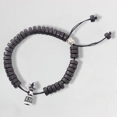 Coconut Shell Dorje Vajra Bracelet – Top-down view of full bracelet with dark beads and silver vajra charm, prayer bracelet
