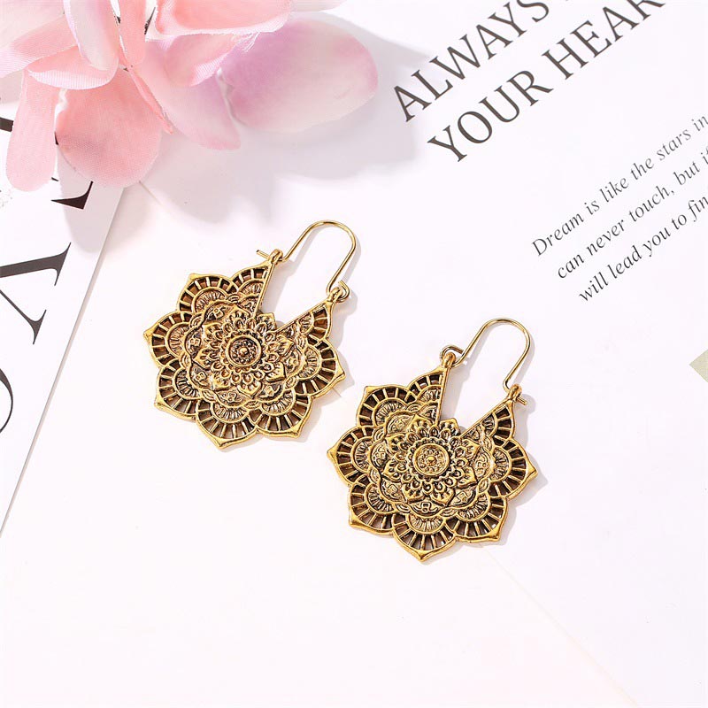 Tibetan Copper Lotus Engraving Drop Earrings – Statement copper mandala earrings featuring elaborate concentric floral patterns with French hooks, displayed on white surface with pink flower accents
