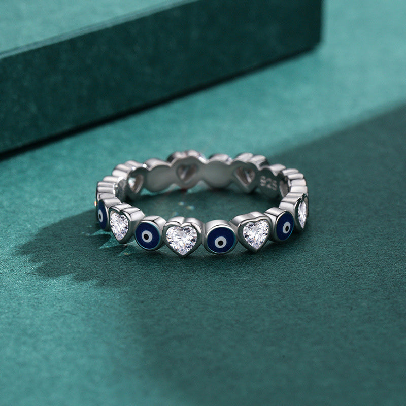 925 Sterling Silver Evil Eye Heart Ring – close-up on teal surface showing heart-shaped zircon and nazar details