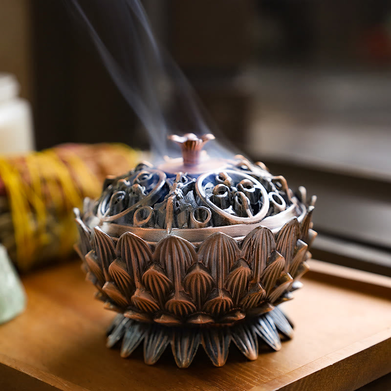 Lotus Incense Burner emitting smoke from perforated lid, vintage bronze on wood, enlightenment