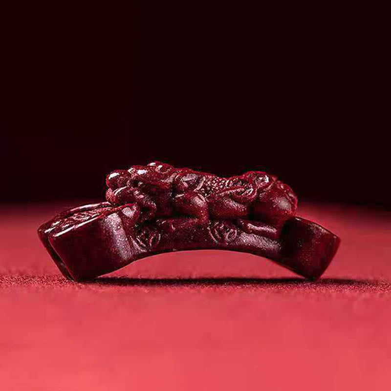 Handcrafted PiXiu Cinnabar Wealth Luck Braided Bracelet – PiXiu component lying flat on red surface, cinnabar piece