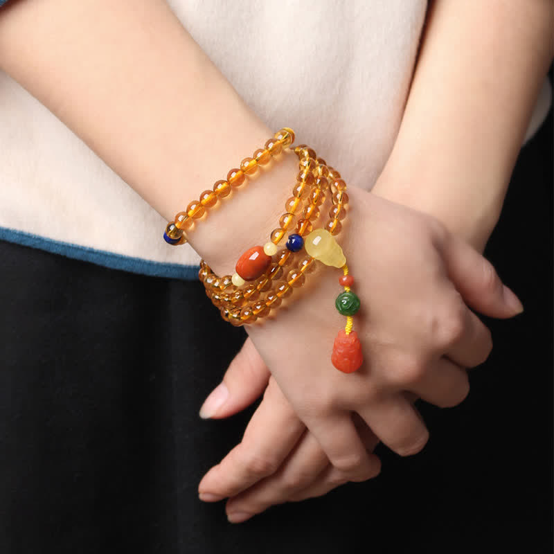 Citrine Mala Bracelet – Woman wearing multi-wrap citrine mala bracelet, white and blue sleeve