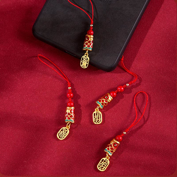 Koi Fish Cinnabar Ruyi Phone Charm – phone charm laid on red fabric, cinnabar koi with ruyi and gold beads