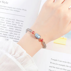 Moonstone PiXiu Bracelet – Wrist shot with white ruffled sleeve over magazine, feminine charm