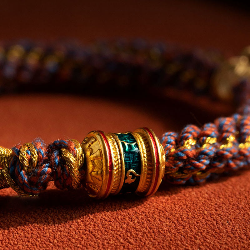 Om Mani Padme Hum Braided Bracelet – Macro detail of gold barrel bead with green enamel inlay on woven cord