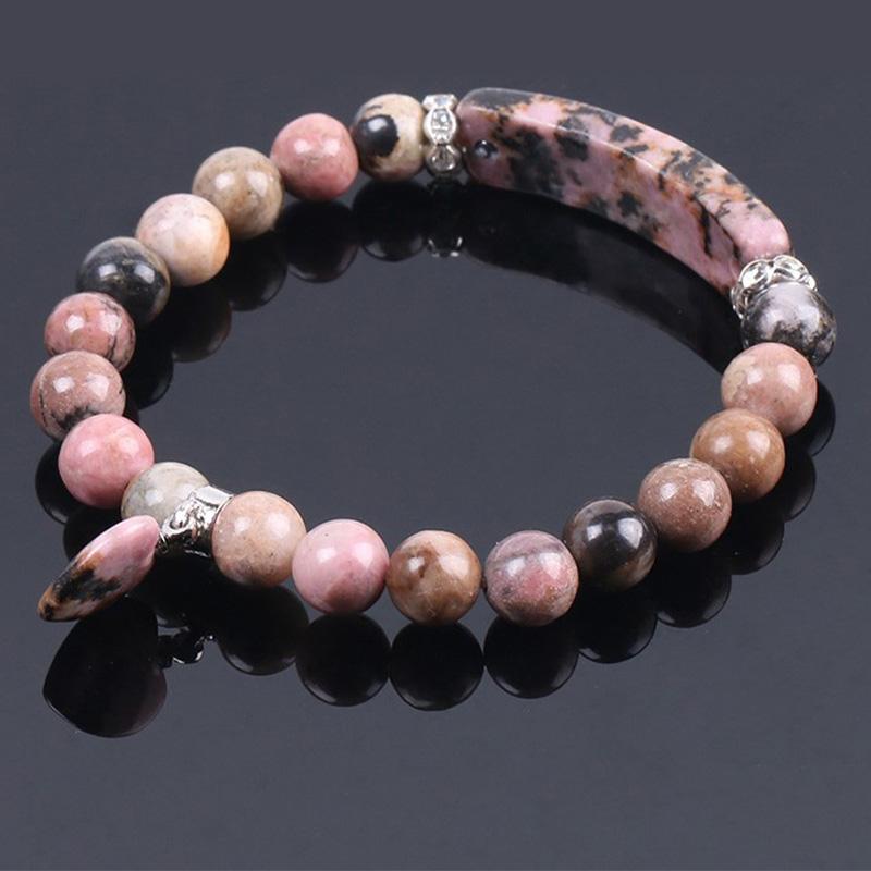 Natural Multi-Stone Love Heart Healing Bracelet - Rhodonite bracelet on glossy black surface with pink-black mottled beads, curved bar centerpiece, and heart charm