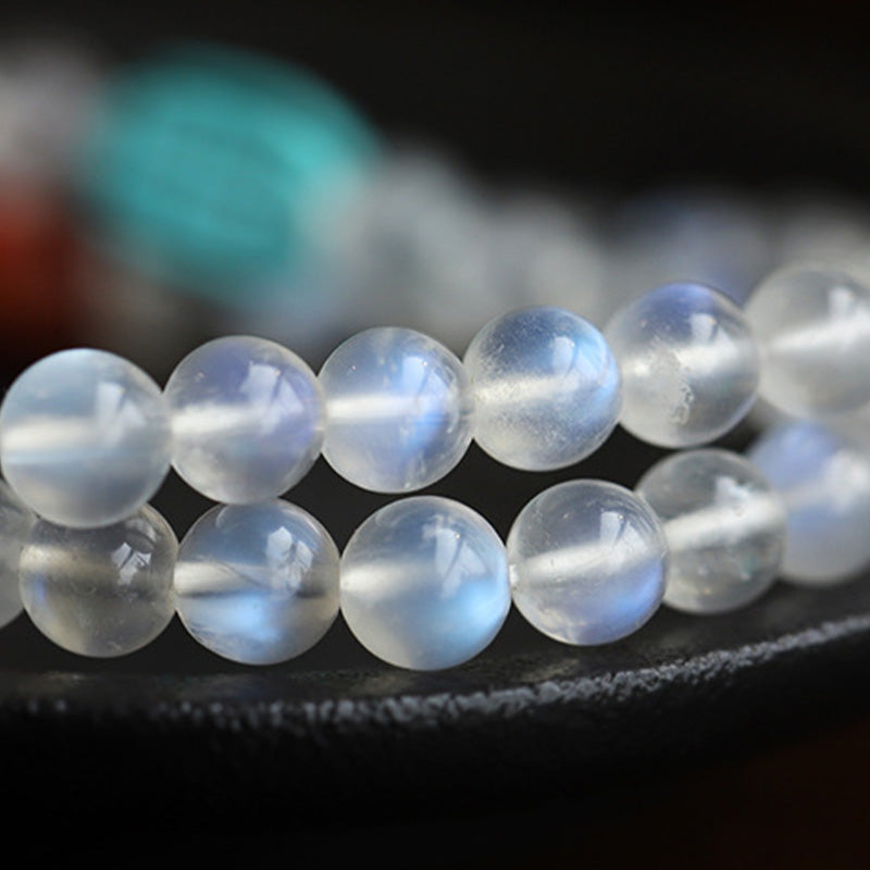 Moonstone Amber Turquoise Lotus Mala - Double-strand moonstone bracelet with blue flash on dark velvet