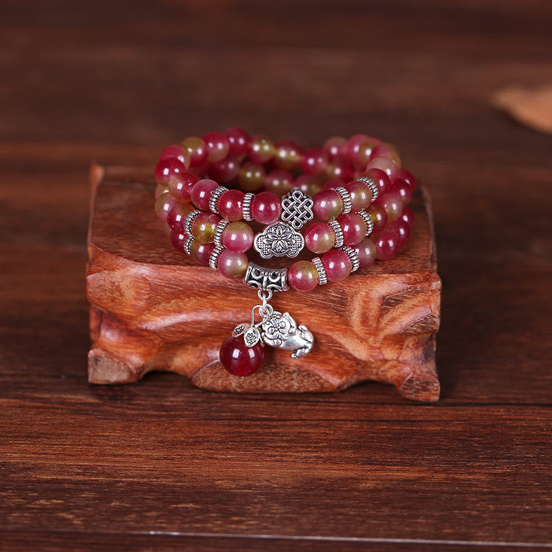 Watermelon Tourmaline Bracelet – Close-up on ornate wood showing silver charms and PiXiu
