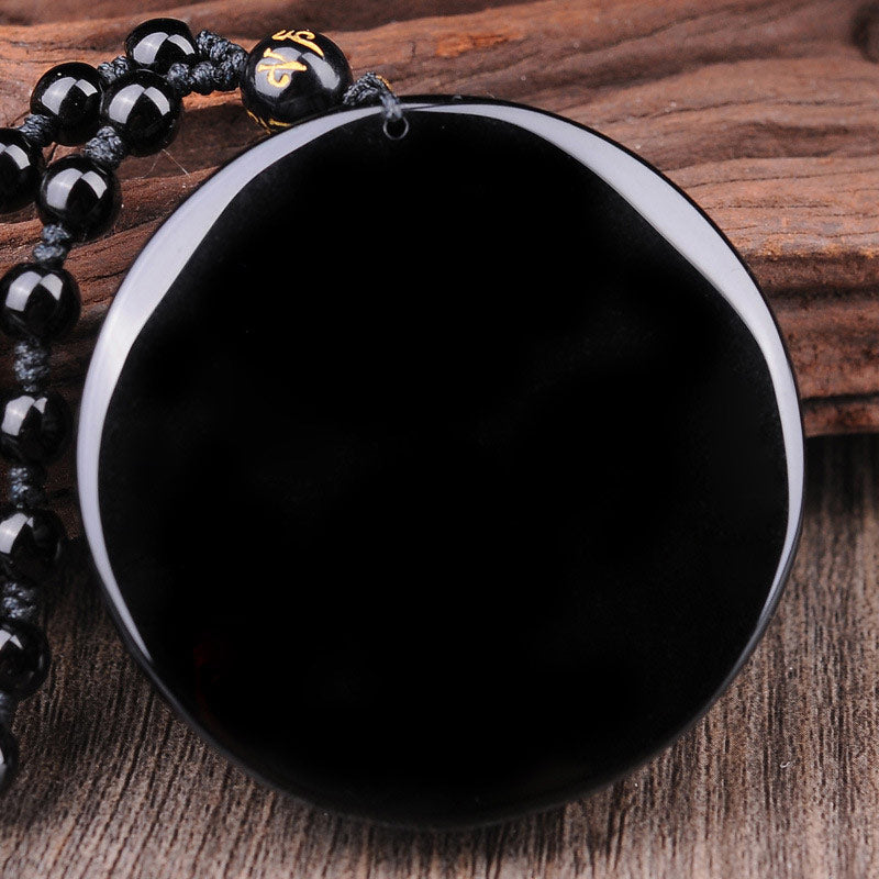 Bagua Dragon Phoenix Obsidian Pendant – Polished obsidian disc on rustic wood, natural healing