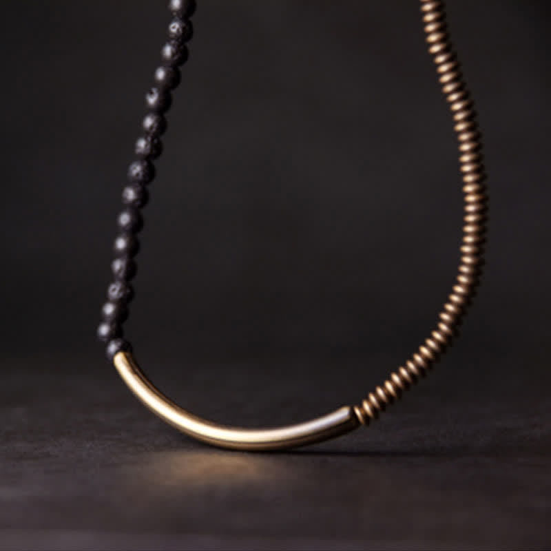 Lava Rock Copper Healing Bracelet – Black volcanic stone bracelet with copper wire-wrap focal, silver-toned metal accents on gray pebbled stone, overhead diagonal