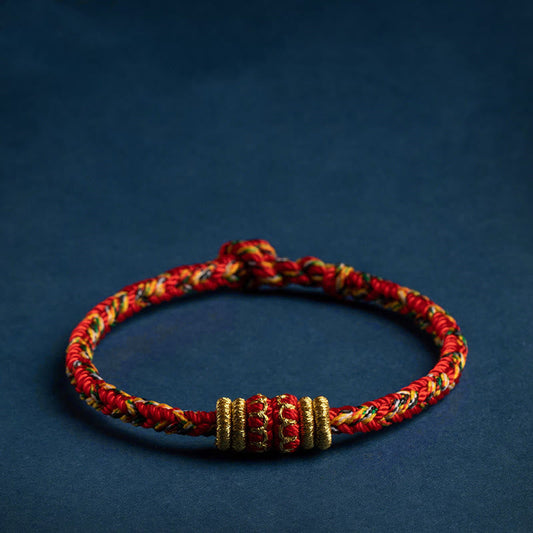 Handmade red braided cord bracelet with gold accent beads, adjustable Chinese knot lucky string bracelet on navy background