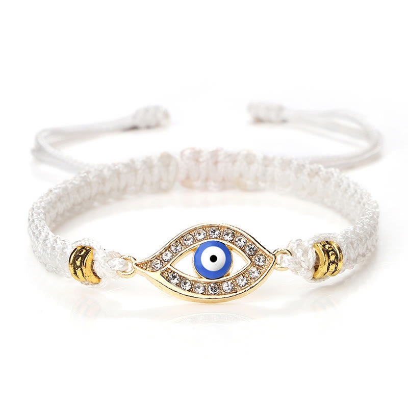 White cord evil eye bracelet with gold blue evil eye crystal charm on white background