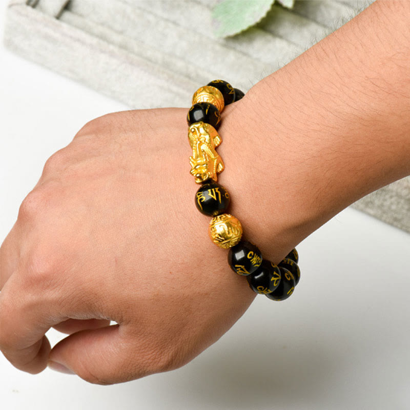 FengShui PiXiu Obsidian Wealth Bracelet - Worn on outer wrist, Pixiu charm with gold Sanskrit beads, natural lifestyle shot