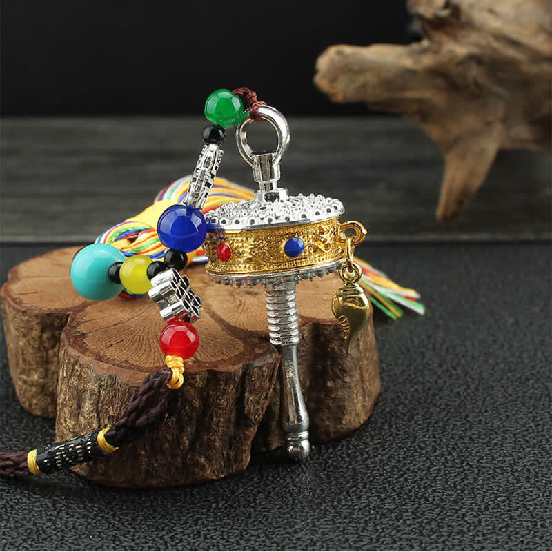 Tibetan Prayer Wheel Tassel – Gold silver prayer wheel with turquoise coral accents on driftwood