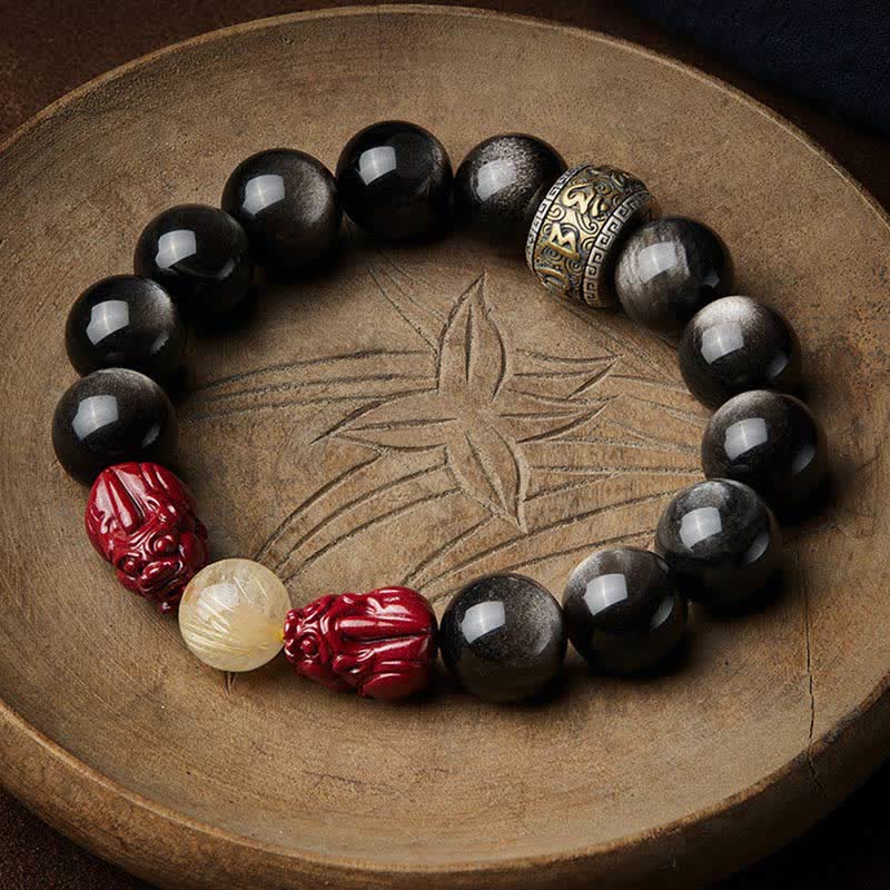 Gold Sheen Obsidian Pixiu Bracelet – top view on carved wood plate with cinnabar pixiu and golden rutilated quartz, feng shui protection