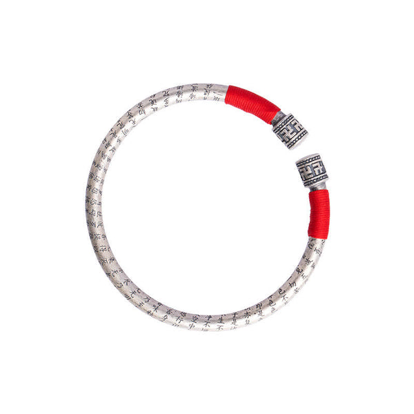Tibetan Red String Bracelet – top-down overhead on white, full silver bangle with red cord ends