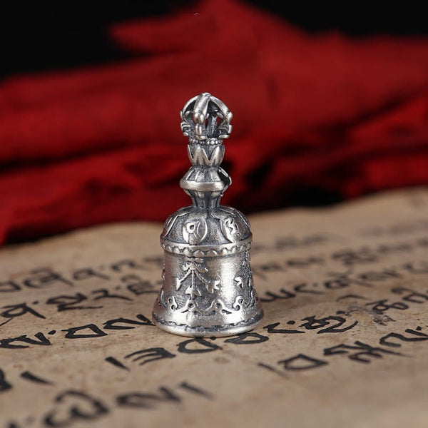 925 Silver Dorje Bell Pendant – Low angle of silver ghanta on Tibetan prayer text with red brocade