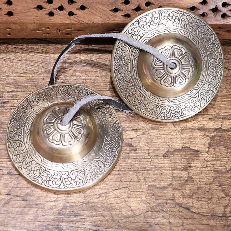 Tibetan Tingsha Bells – Handcrafted pair with lotus dome engraving and leather strap on rustic wood, meditation cymbals Main image