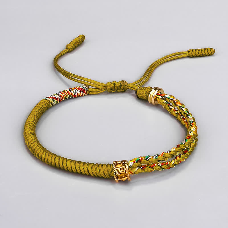 Om Mani Padme Hum Red String Bracelet – Mustard yellow braided rope with multicolor woven section and gold square charm bead on neutral gray background