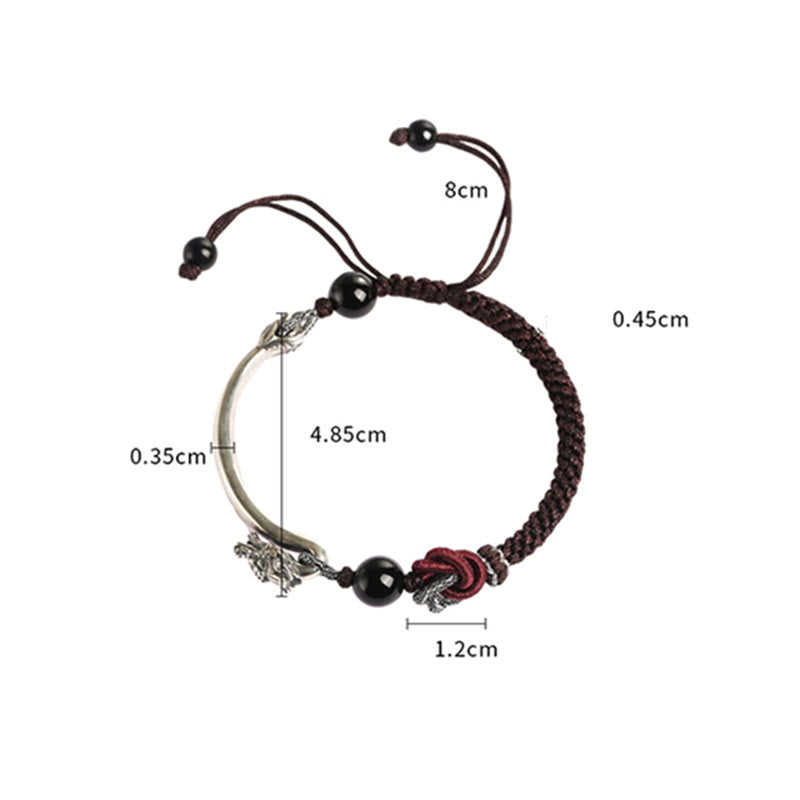 Dragon Braided Bracelet – gold brocade table runner with intricate floral design on dark wood, festive