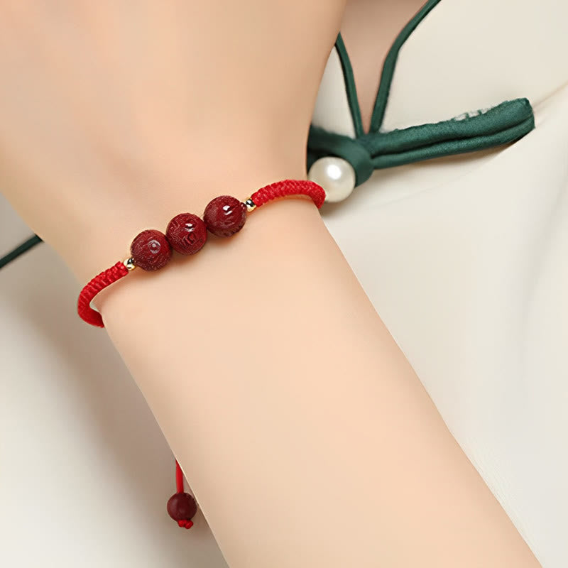 Cinnabar Om Mani Padme Hum Braided Bracelet – Worn on wrist with green-trim top, carved red bead bracelet