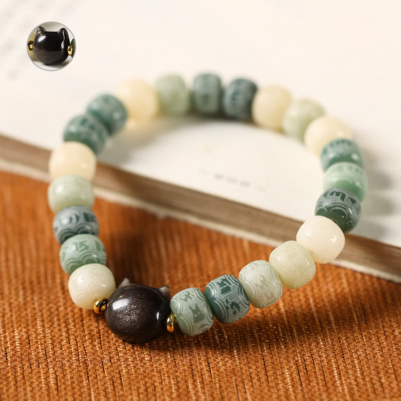 Bodhi Seed Cat Head Bracelet – Green carved beads with obsidian cat head on terracotta fabric, close-up with inset detail view