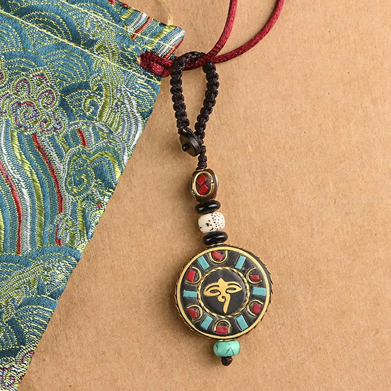 Tibetan Bodhi Seed Peace Key Chain – Gold Om medallion with stone inlay and cord, close-up detail, spiritual gift
