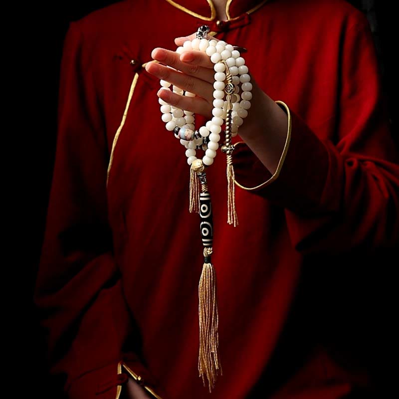 108 Mala Beads Bracelet – White beads held in hands, dzi bead and tassel
