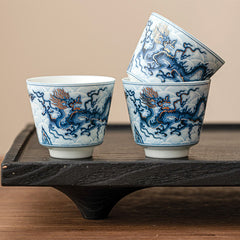 Blue & White Dragon Ceramic Teacup – three cups stacked on black tea tray, gold dragon accents, ceremonial
