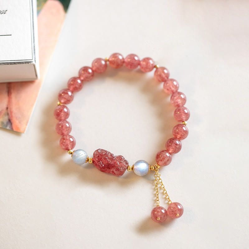 Strawberry Quartz Moonstone Bracelet – flat lay white surface book corner, pink quartz beads, love luck