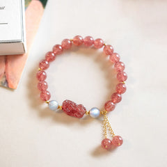 Strawberry Quartz Moonstone Bracelet – flat lay white surface book corner, pink quartz beads, love luck