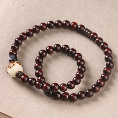 Red Sandalwood Lotus Bodhi Seed Bracelet – Double-loop dark sandalwood beads with carved cream lotus focal bead, flat lay