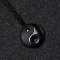 Black Obsidian Nine-Character Mantra Necklace – Polished Yin-Yang obsidian pendant flat lay, carved stone necklace