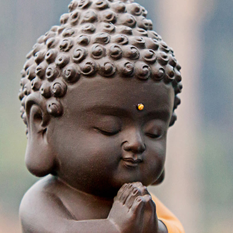 Small Buddha Purple Clay Decoration – tight portrait crop of face and prayer hands, golden urna dot, baby Buddha serenity
