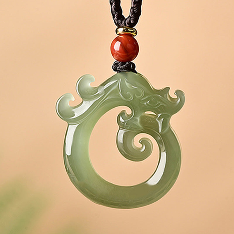 White Jade Cyan Jade Dragon Pendant – carved spiral dragon in sage green with red bead, auspicious