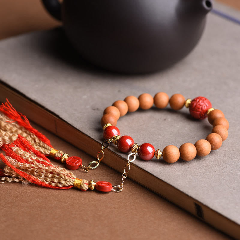 Peach Wood PiXiu Wealth Bracelet – Close-up wood beads with red cinnabar on gray paper, prayer bracelet