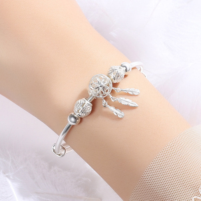Dream Catcher Blessing Bracelet – Inner wrist view showing dreamcatcher web and feather pendants, lifestyle jewelry