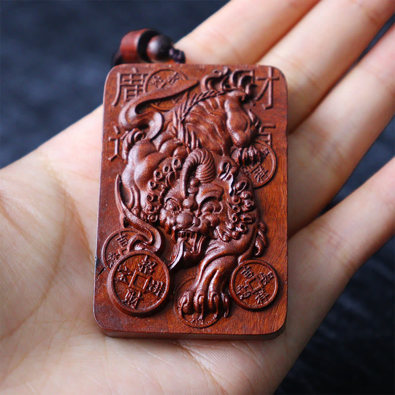 Lightning Struck Jujube Wood PiXiu – Hand holding carved wood PiXiu pendant scale