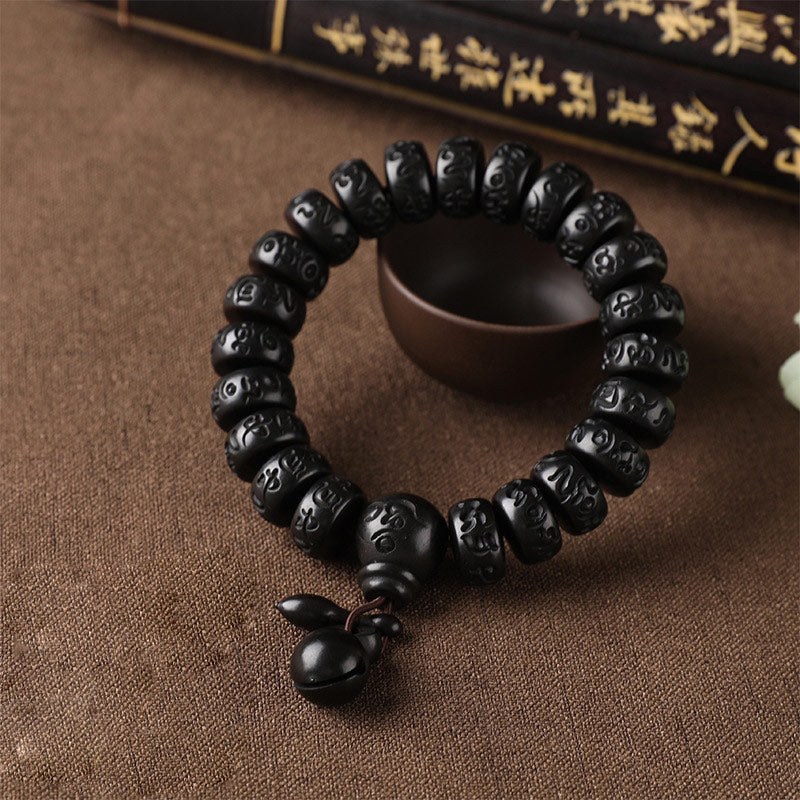 Lightning Strike Wood Bracelet – Black beaded bracelet with focal bead and bell on rustic fabric, carved wood