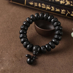 Lightning Strike Wood Bracelet – Black beaded bracelet with focal bead and bell on rustic fabric, carved wood