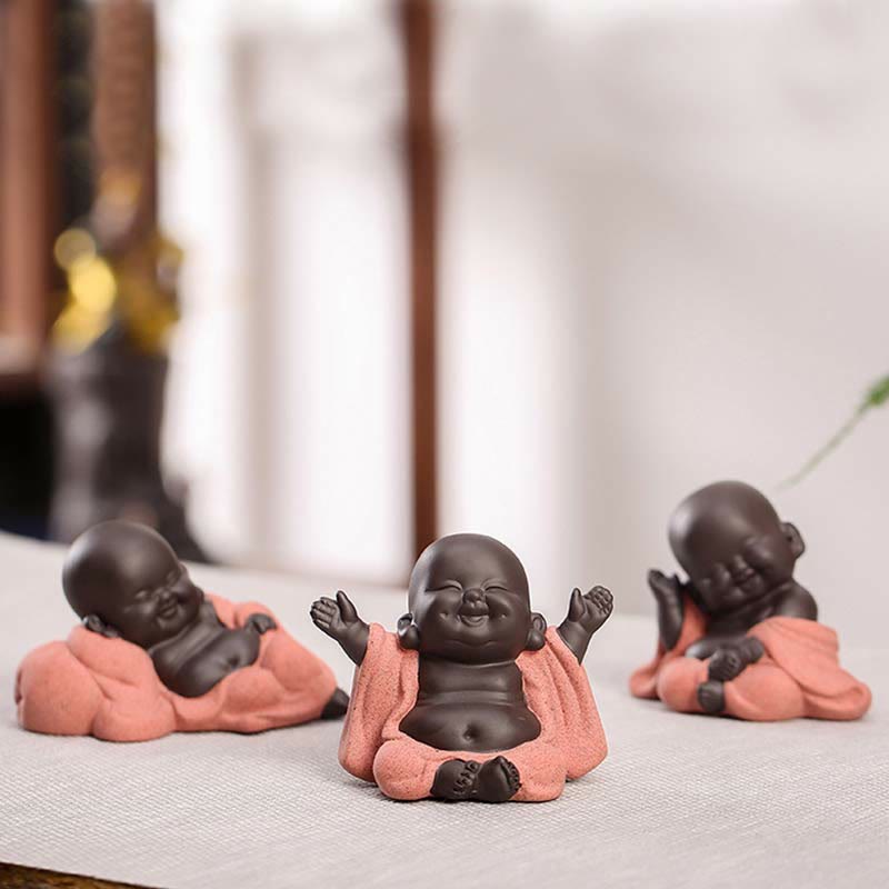 Laughing Buddha Purple Clay Maitreya Statue – front view of monk in prayer pose with off-white speckled robe and dark clay head, hands clasped meditation mudra