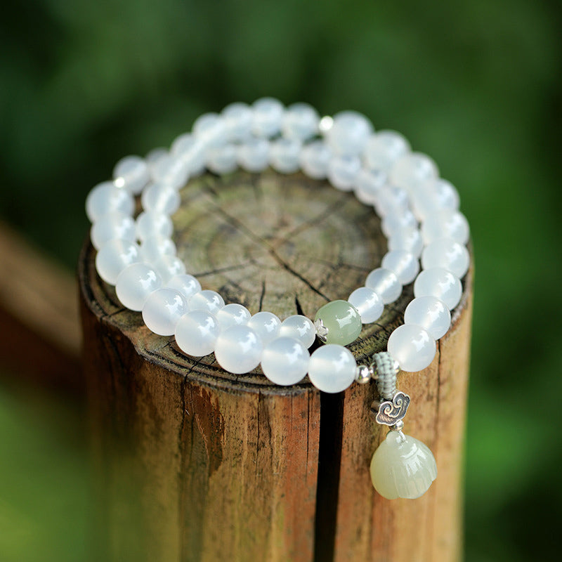 White Agate Jade Lotus Bracelet - Three-strand beads with carved lotus charm on weathered wood, natural stone jewelry